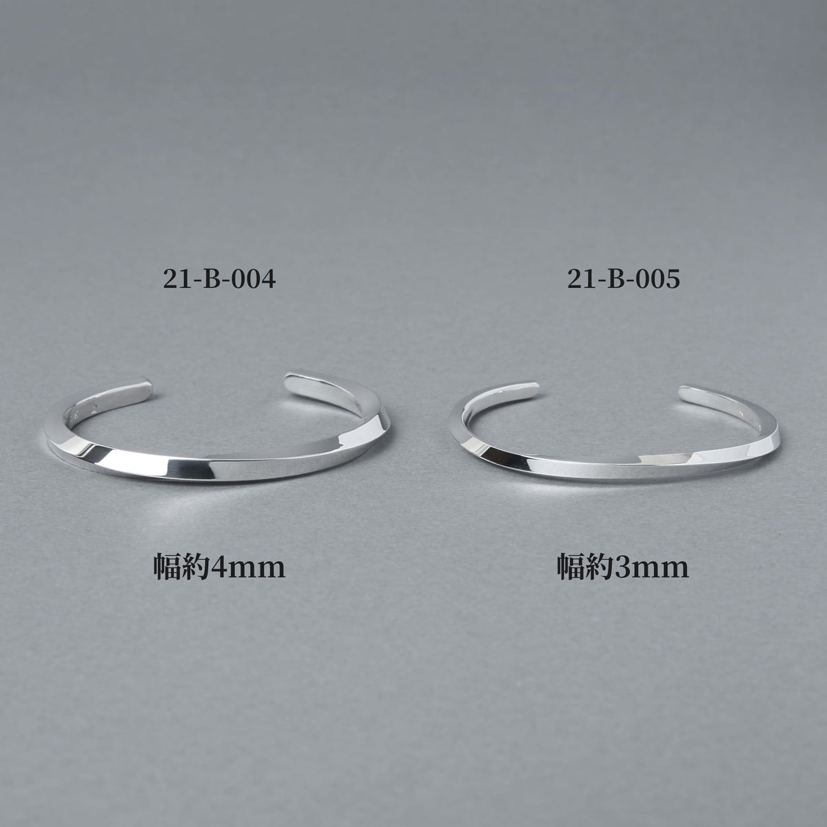 品番21-B-004(幅約4mm)と21-B-005(幅約3mm)のシルバーバングルを並べた比較画像。プレーンでフラットなフォルムの幅違いデザインをグレー背景で撮影した商品イメージ。